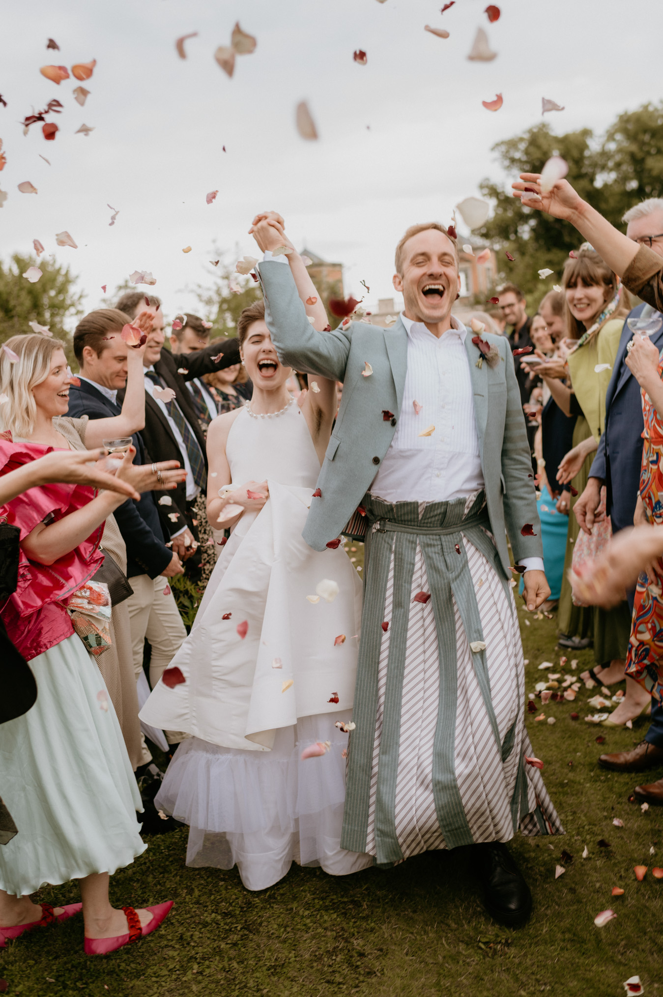 bride and groom running through confetti