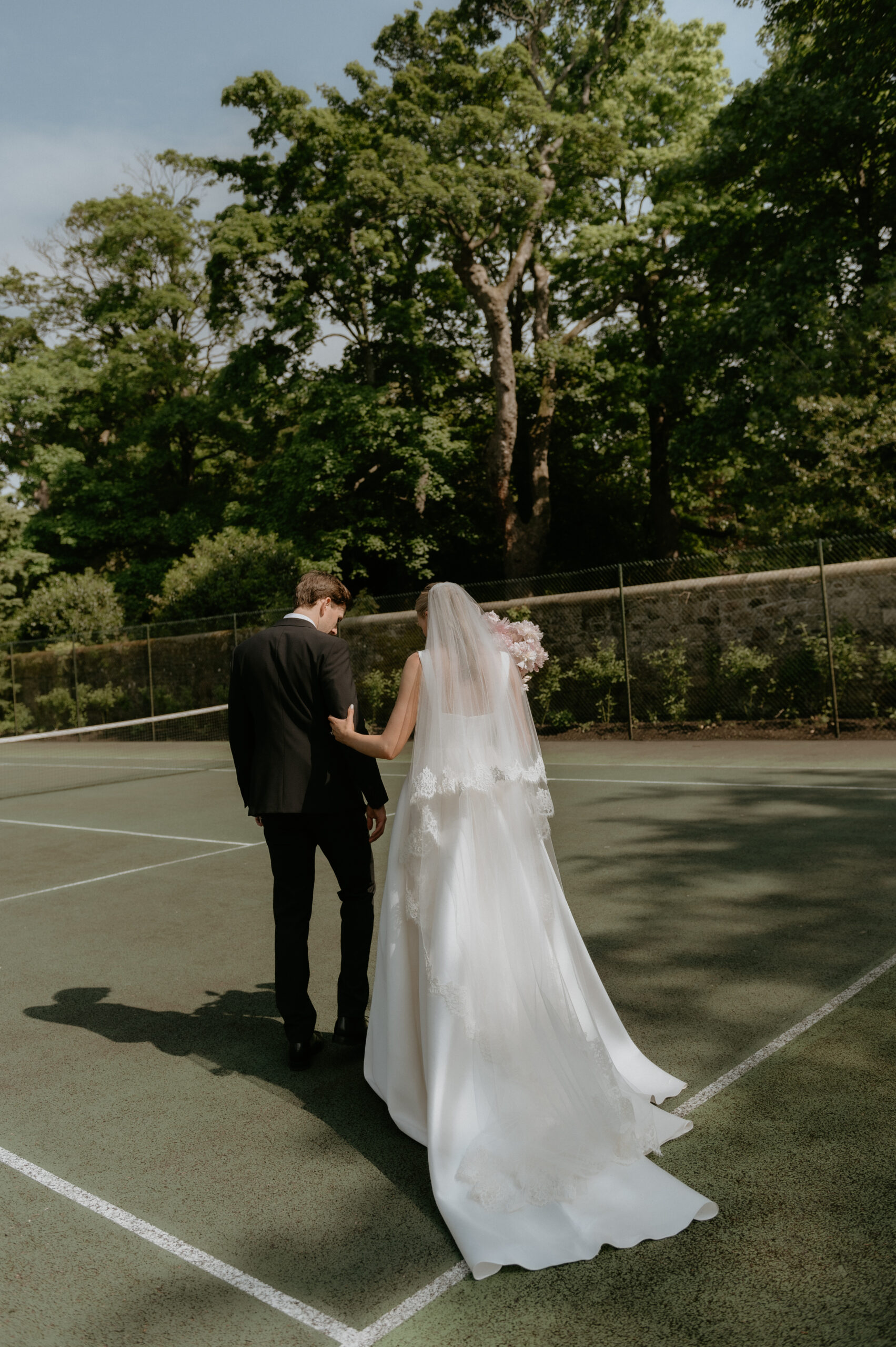 modern portrait of bride and groom on tennis court